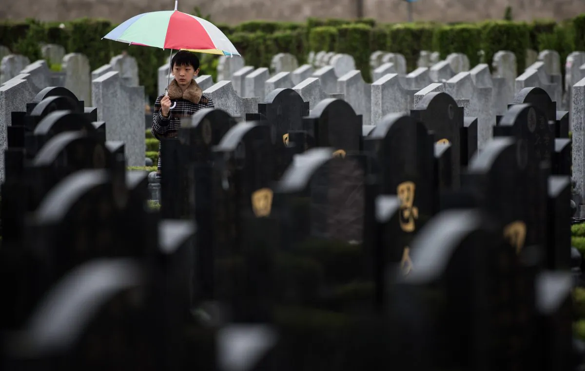 A boy stands between graves during the annual "Qingming" festival, or Tomb Sweeping Day, at a public cemetery in Shanghai on April 6, 2015. (Johannes Eisele/AFP/Getty Images)