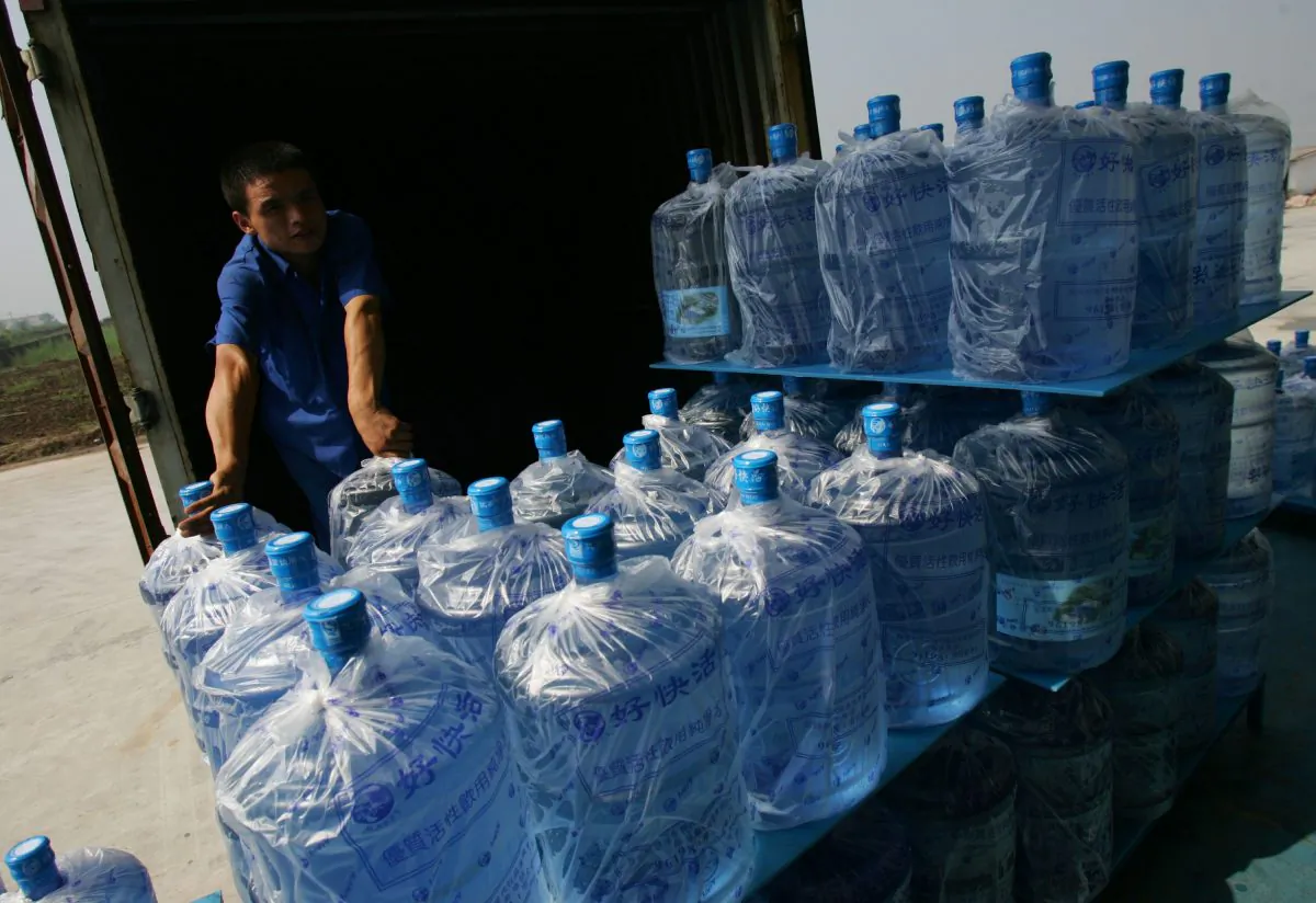 A worker loads bottled drinking water onto a van at a bottling factory July 22, 2007 in Xian of Shaanxi Province, China. One sixth of the 650,000 filtered water bottles sold in Beijing daily contain water from the tap, according to Beijing Association for Barreled Drinking Water. (China Photos/Getty Images)