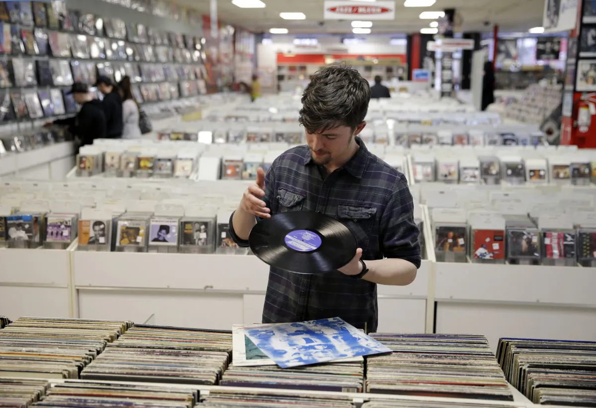 Record clerk Josh Kelly wipes a dust speck from a used LP record as he put it in a sales bin at Vintage Vinyl Records Tuesday, in Fords, N.J., on April 14, 2015. (AP Photo/Mel Evans)