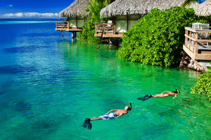 Young couple snorkeling in clean water over coral reef via Shutterstock*