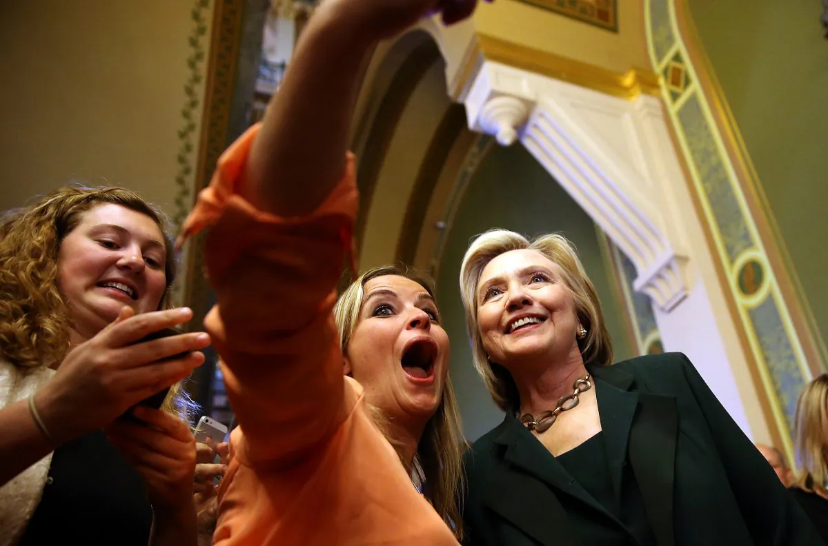 Democratic presidential hopeful and former Secretary of State Hillary Clinton (R) stops to take a selfie after meeting with members of the Iowa State legislature at the Iowa State Capital on April 15, 2015 in Des Moines, Iowa. (Justin Sullivan/Getty Images)