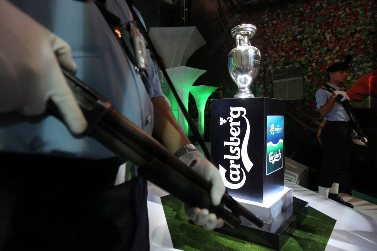Security guards in Malaysia are posted next to the UEFA Euro 2012 trophy on display at a shopping mall in Bandar Sunway on April 6, 2012. Officials in Malaysia say that triads are infiltrating the country's security companies. (MOHD RASFAN/AFP/Getty Images)