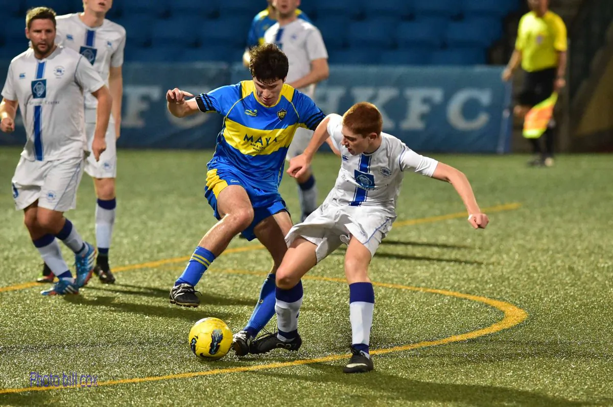  Colts (white kit) and Boca Seniors (blue kit) vie for the ball during Colts 4-nil win in the Yau Yee League, Division 1 match at Sports Road on Sunday April 19, 2015. (Bill Cox/Epoch Times) 