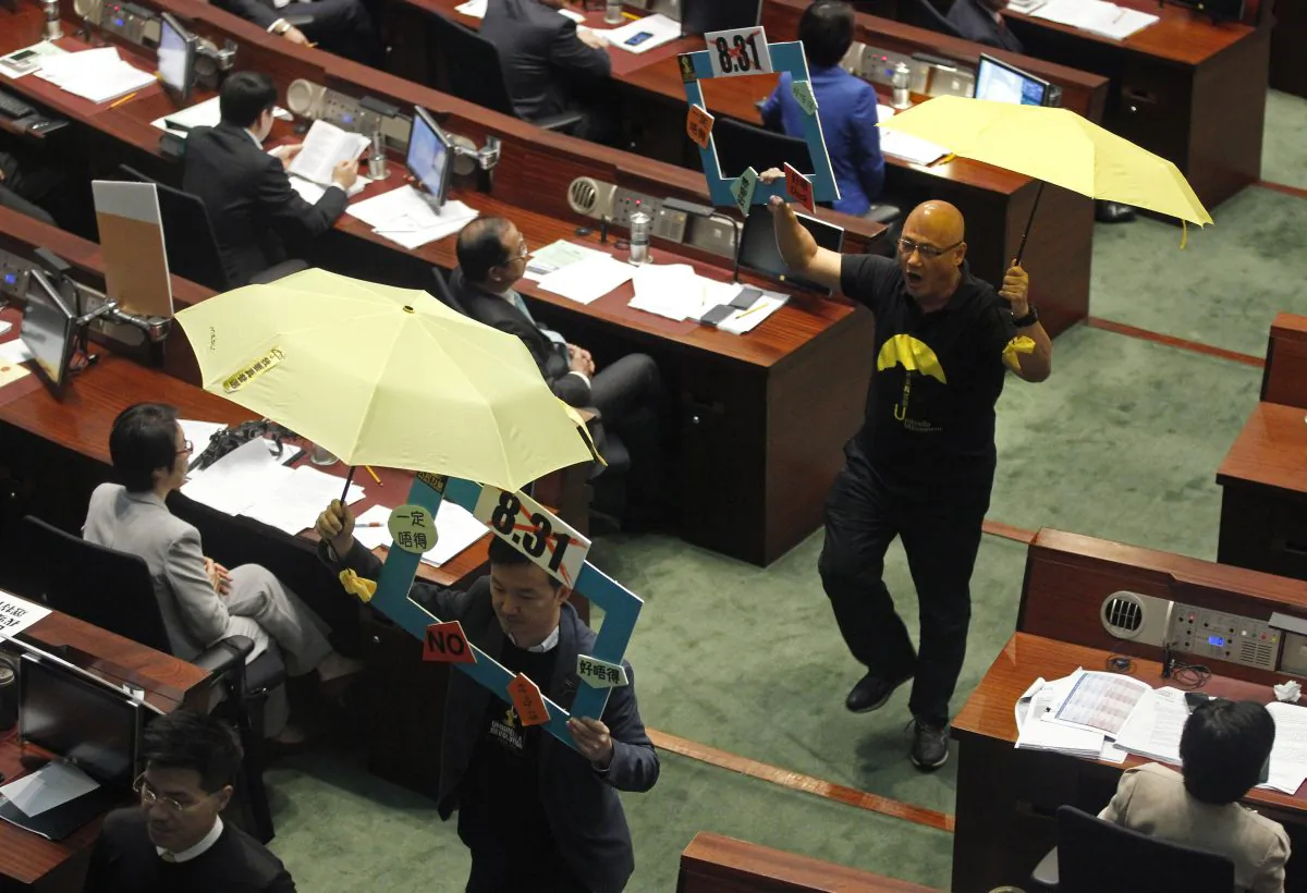 Pro-democracy lawmakers walk out of the legislative chamber after Chief Secretary Carrie Lam unveiled the Beijing-backed election reform package details in Hong Kong  April 22, 2015. (AP Photo/Vincent Yu)