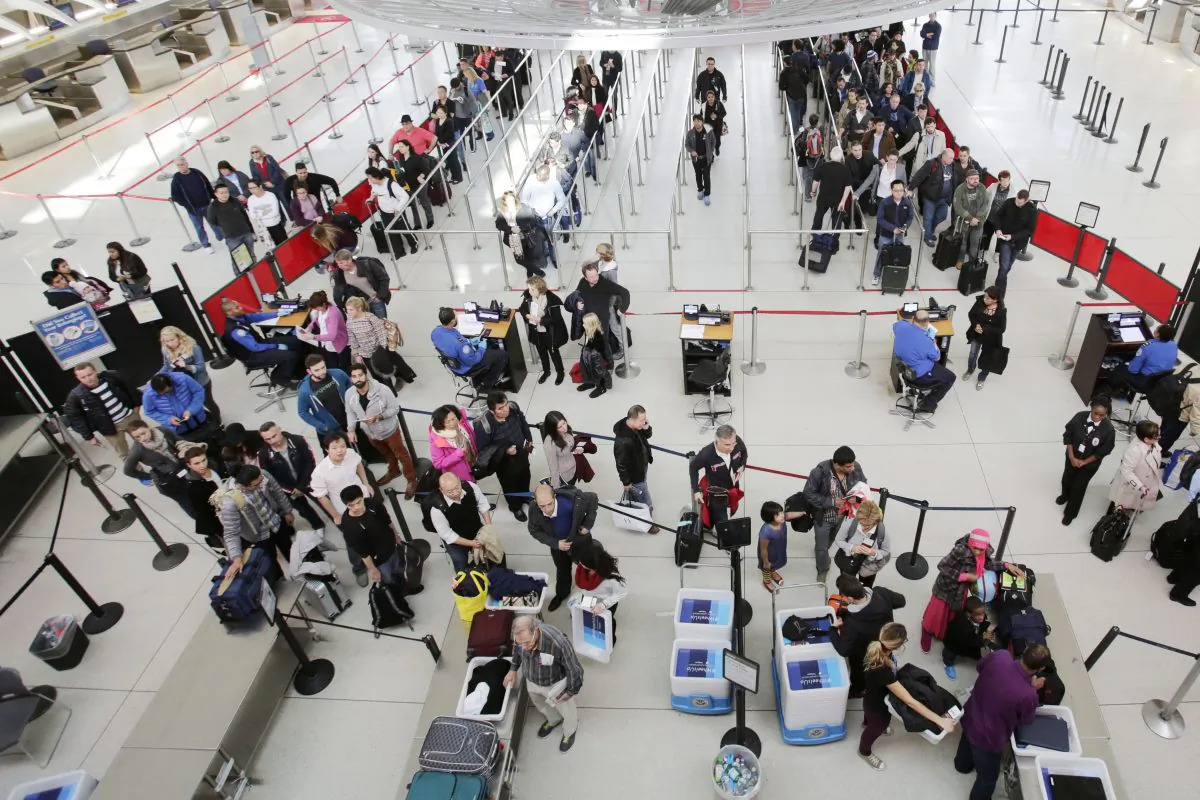 In this Oct. 30, 2014 photo, passengers line up to pass through security before boarding flights at John F. Kennedy International Airport in New York. (AP Photo/Mark Lennihan)