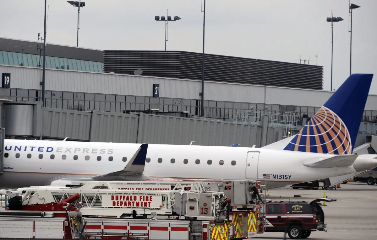 Emergency vehicles surround a SkyWest Airlines plane, operating as United Express, that made an emergency landing at Buffalo Niagara International Airport, Wednesday, April 22, 2015, in Cheektowaga, N.Y. A SkyWest spokeswoman said one passenger aboard Flight 5622, lost consciousness and the pilots rapidly descended "out of an abundance of caution." (AP Photo/Gary Wiepert)