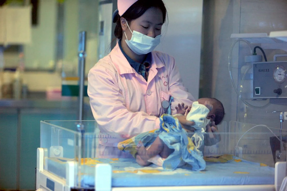 A nurse looks after a rescued baby in a hospital in Xichang, southwest China's Sichuan province, on Dec. 18, 2012. A baby smuggling ring was recently broken up in China. (STR/AFP/Getty Images)