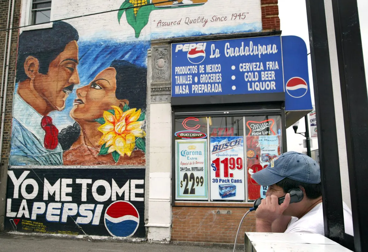A Hispanic man talks on a public phone near a Pepsi wall ad in Spanish in Chicago's mainly Hispanic Little Village neighborhood on Sept. 22, 2003. (Tim Boyle/Getty Images)