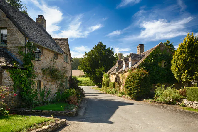 Ancient cotswold stone houses and flower garden in Cotswolds via Shutterstock*
