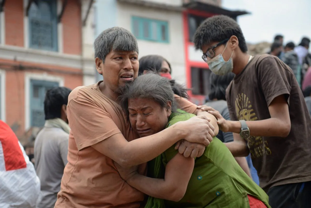A Nepalese man and woman hold each other in Kathmandu on April 25, 2015 after the devastating 7.8 magnitude earthquake.(Prakash Mathema/AFP/Getty Images)