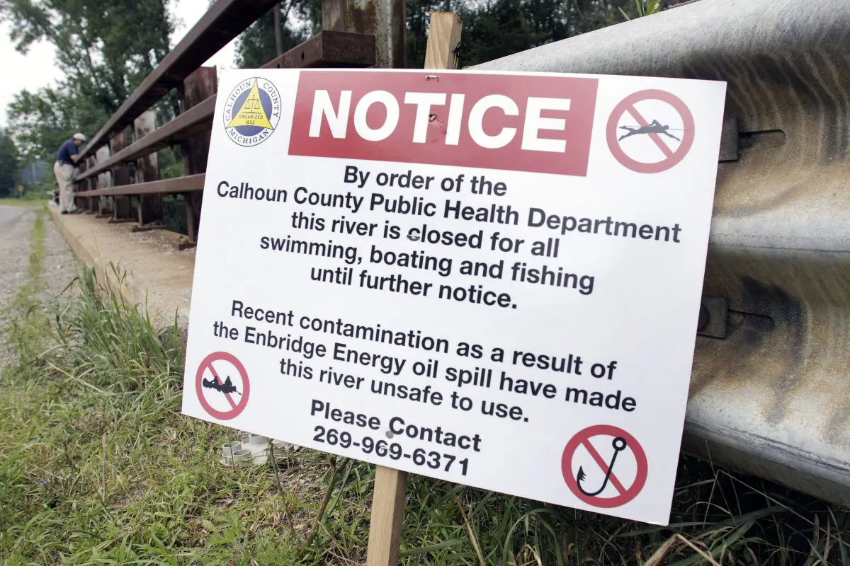 A sign is posted on a bridge to indicate water contamination after an oil spill of approximately 800,000 gallons of crude in the Kalamazoo River on July 28, 2010 in Marshall, Mich. (Bill Pugliano/Getty Images)