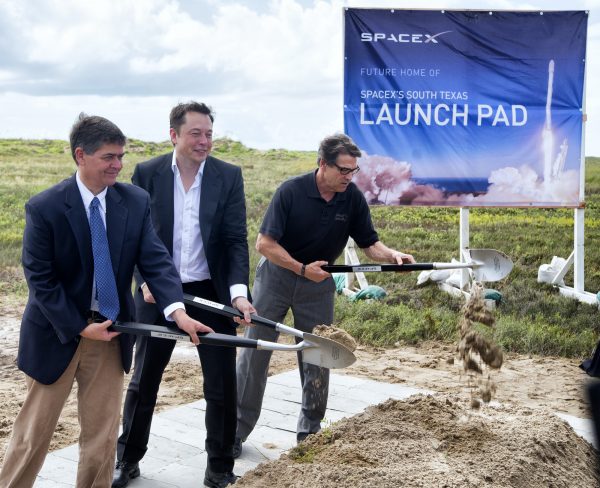 In a Sept. 22, 2014 file photo, U.S. Rep. Filemon Vela, left, SpaceX founder and CEO Elon Musk, center, and Texas Gov. Rick Perry turn the first shovel-full of sand at the groundbreaking ceremony for the SpaceX launch pad at Boca Chica Beach, Texas. The SpaceX venture, led by PayPal co-founder and electric car maker Musk, is one of two parts of the 21st-century space race being directed in the Texas by Internet billionaires.(AP Photo/Valley Morning Star, David Pike)
