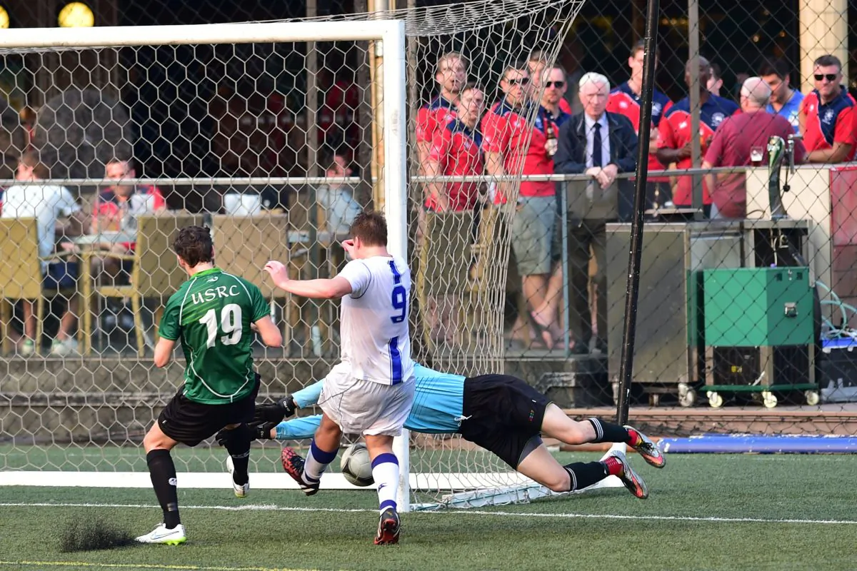 USRC goalkeeper saves under pressure from Albion's Robert Gasper (white) during their Yau Yee League Division 1 match at Sports Road on Sunday April 26, 2015. Albion won a close competitive match 1-nil to become Division 1 Champions. (Bill Cox/Epoch Times)