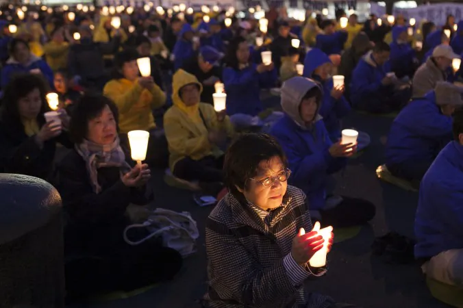 Falun Dafa practitioners hold a candlelight vigil as a peaceful protest near the Chinese Consulate in New York, on April 25, 2014. Falun Gong practitioners have peacefully exposed the persecution of their beliefs in China. (Samira Bouaou/Epoch Times)