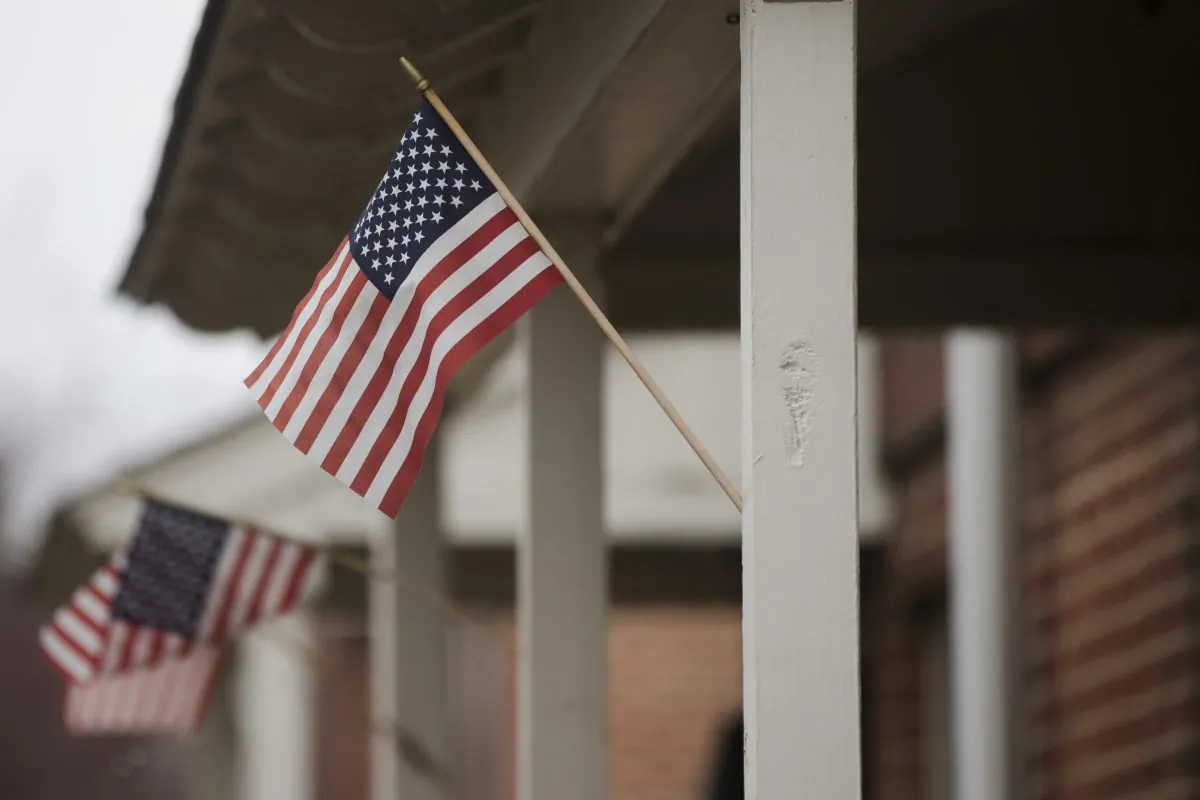 Flags are posted on the home of a woman who is accused of trying to join and martyr herself for the Islamic State group in Syria, Friday, April 3, 2015, in Philadelphia. (AP Photo/Matt Rourke)