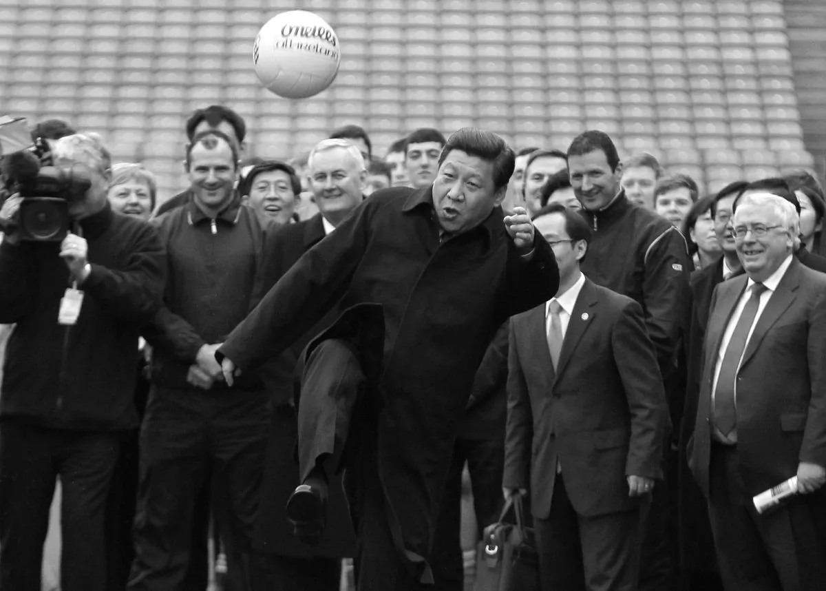 Then Chinese deputy leader Xi Jinping (C) kicks a Gaelic football as he visits at Croke Park in Dublin, Ireland on February 19, 2012. (Peter Muhly/AFP/Getty Images)