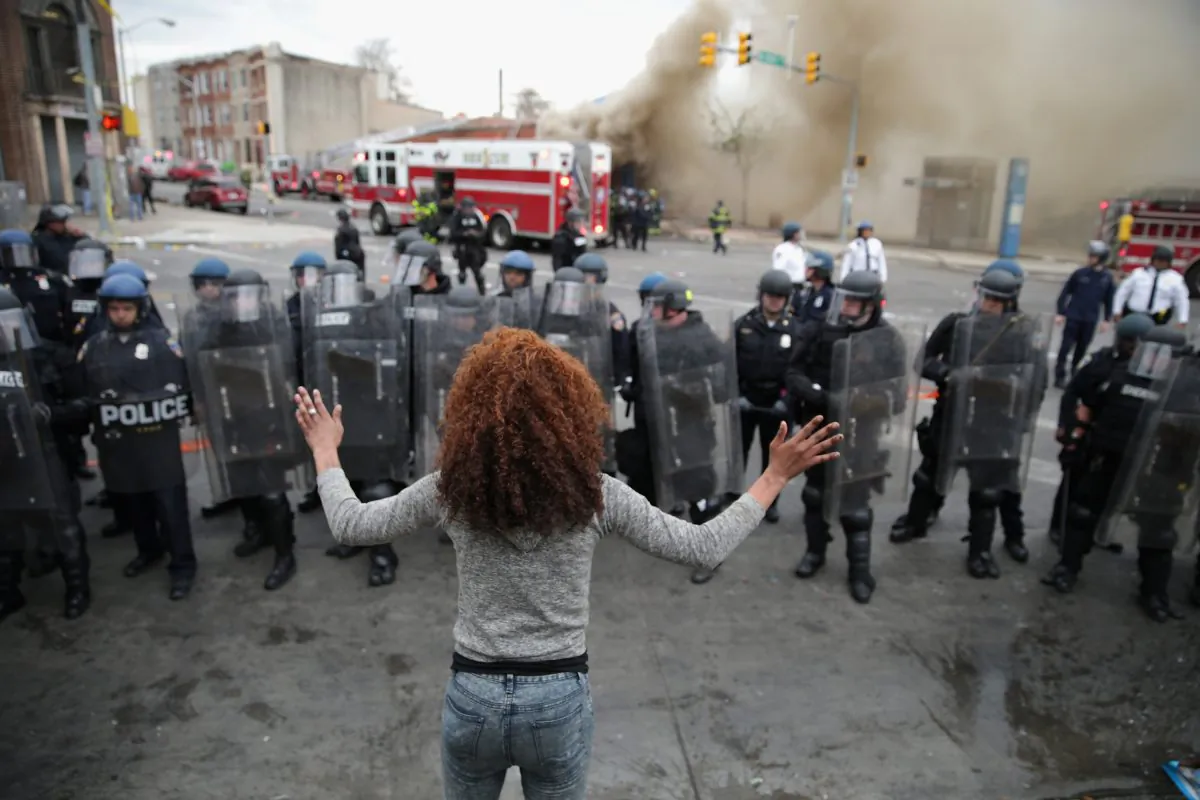 A woman faces down a line of Baltimore Police officers in riot gear during violent protests following the funeral of Freddie Gray April 27, 2015 in Baltimore, Maryland. (Chip Somodevilla/Getty Images)