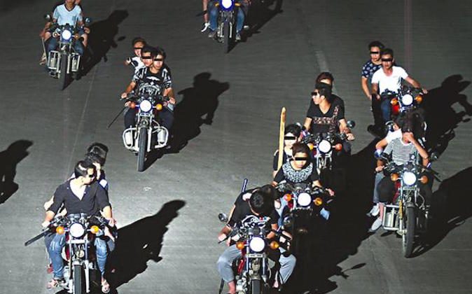 Knife-wielding bikers on the move in an undated photo. (Screen shot/Apple Daily) 