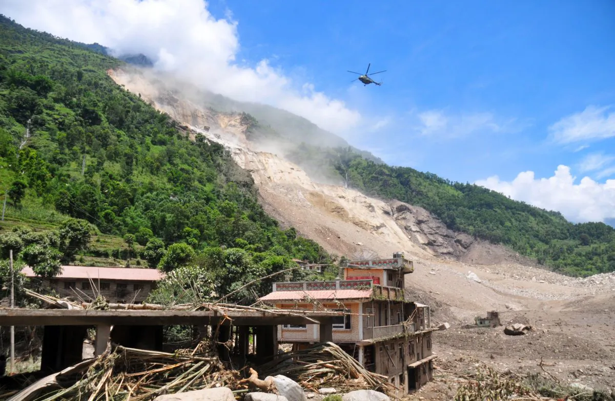 A Nepalese Army helicopter flies over the site of a landslide during a rescue operation in Sindhupalchowk area, about 120 kilometers (75 miles) east of Katmandu, Nepal, Saturday, Aug. 2, 2014. (AP Photo/Dinesh Gole)