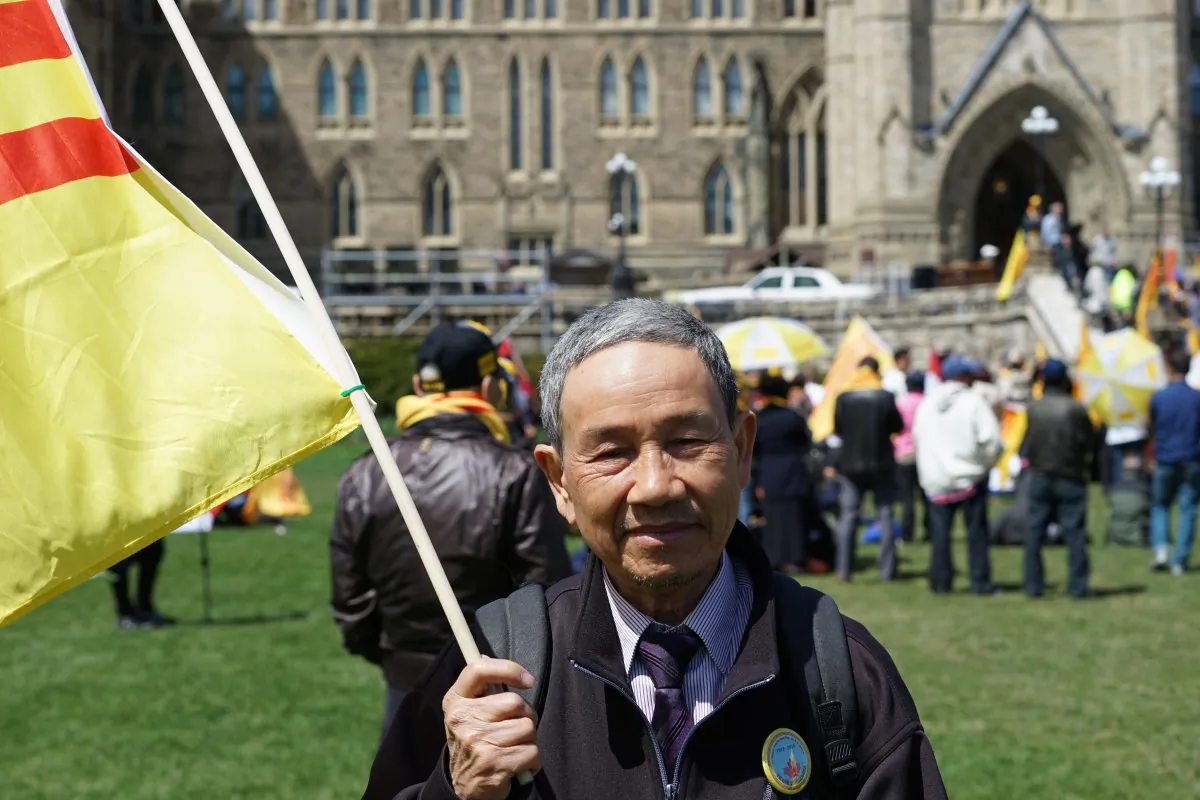 Mien Nguyen holds a flag at the Journey to Freedom Day rally on Parliament Hill, April 30, 2015. Nguyen and his family walked through Cambodia to Thailand to escape from Vietnam before they eventually made it to Canada. (Pam McLennan/Epoch Times)