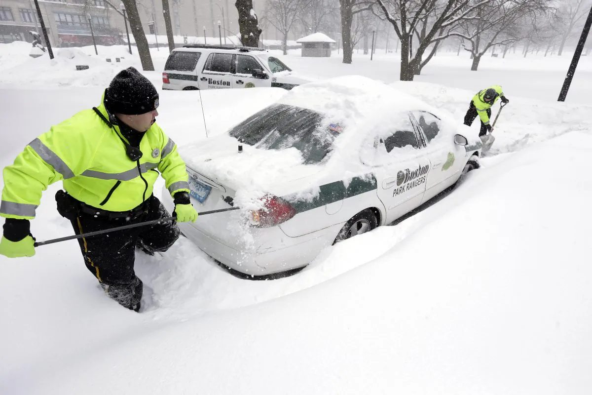 Boston park rangers clear snow from around their car in Boston, on Feb. 9, 2015. (AP Photo/Steven Senne)