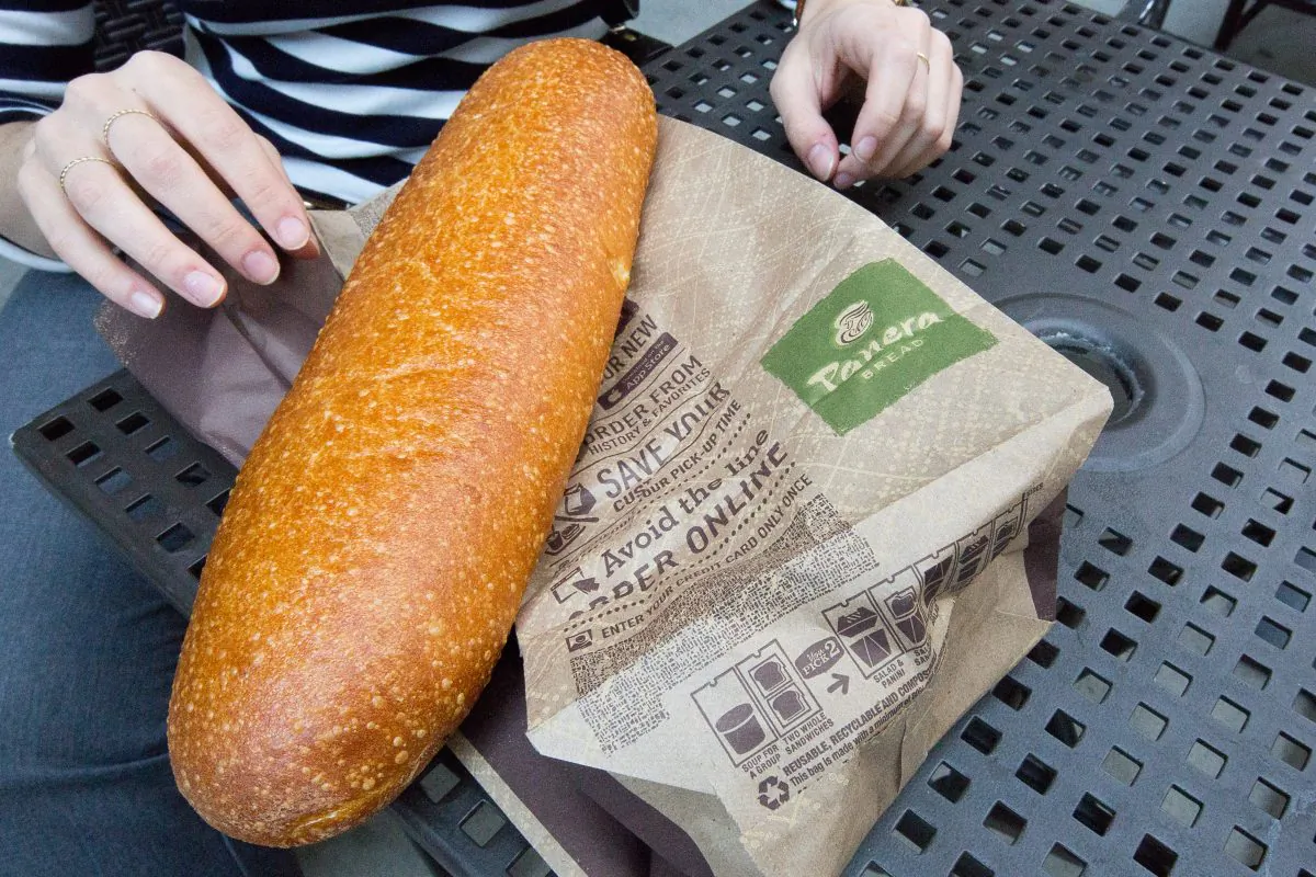 A customer with a bread purchased at a Panera Bread store in Chelsea, Manhattan, on May 5, 2015. (Petr Svab/Epoch Times)