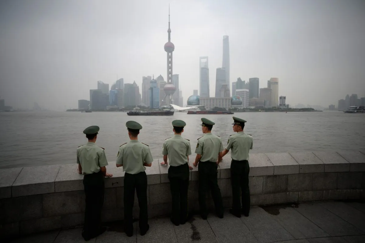 Paramilitary policemen stand in front of the skyline of the Lujiazui Financial District in Pudong in smog in Shanghai on September 29, 2014. (Johannes Eisele/AFP/Getty Images)