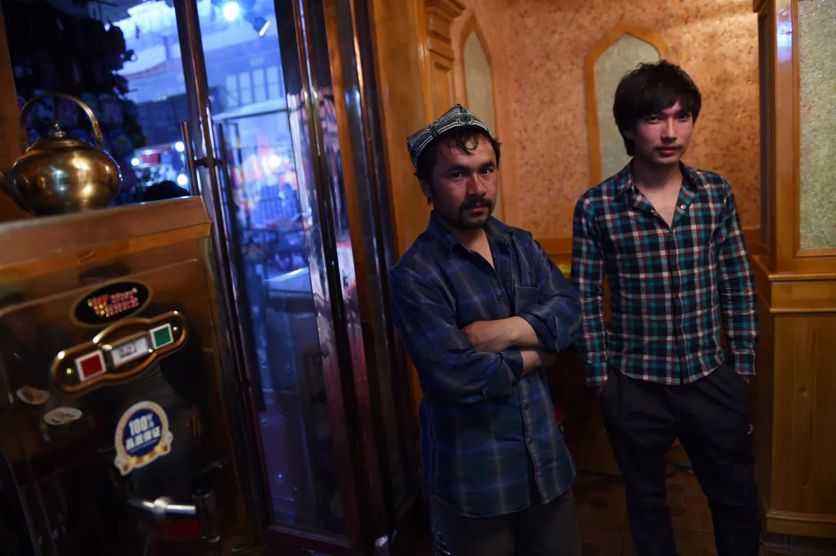 Two Uyghur men stand in a restaurant in Hotan, in China's western Xinjiang region, April 15, 2015. (Greg Baker/AFP/Getty Images)