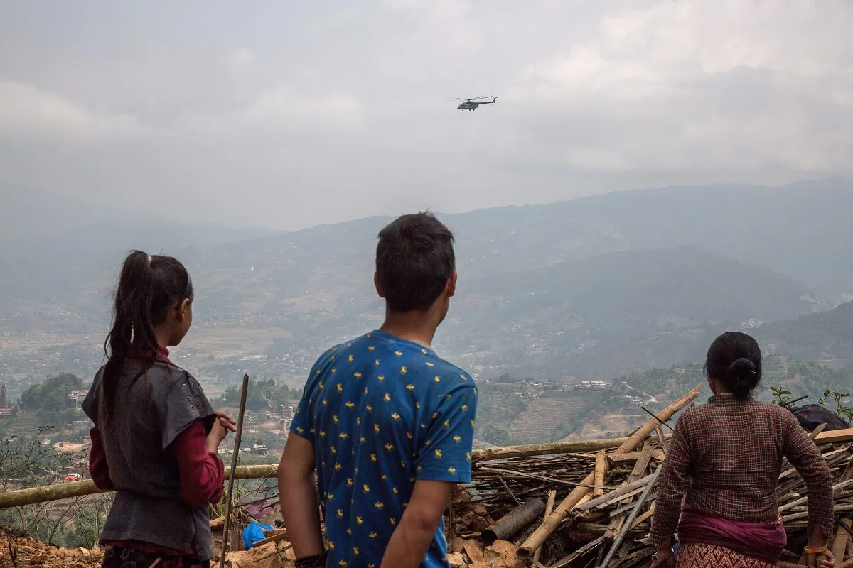 Residents look at a helicopter delivering aid in remote areas of quake-struck Nepal on May 1, 2015 in Kalchowk, Nepal. (Omar Havana/Getty Images)