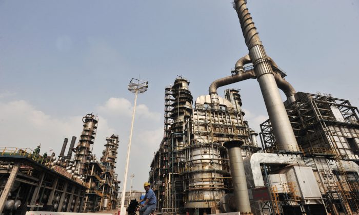 A worker rides a bicycle at an oil refinery of China's Sinopec, in Wuhan, central China's Hubei Province on May 10, 2011. (STR/AFP/Getty Images)