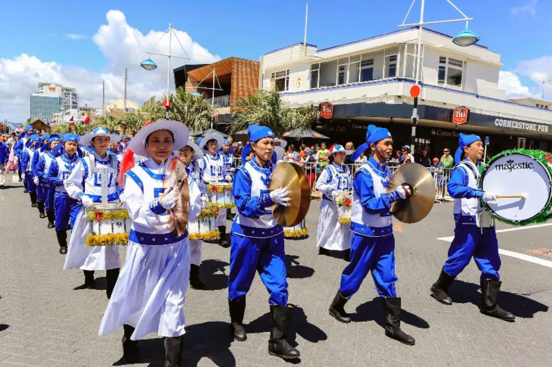 The Divine Land Marching Band composed entirely of Falun Gong practitioners take part in the downtown Tauranga Trustpower Christmas Parade in Auckland, New Zealand, on Nov. 29, 2014. (Courtesy of en.Minghui.org)