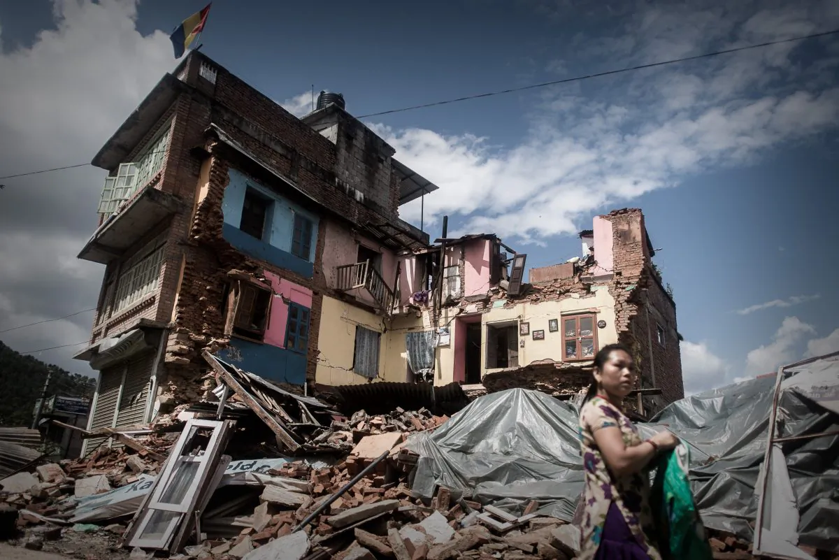 A woman walks past a destroyed house in Chautara, Nepal on April 30, 2015. Last week, aide workers rescued 4 men trapped under rubble in Chautara using radar technology. (PHILIPPE LOPEZ/AFP/Getty Images)