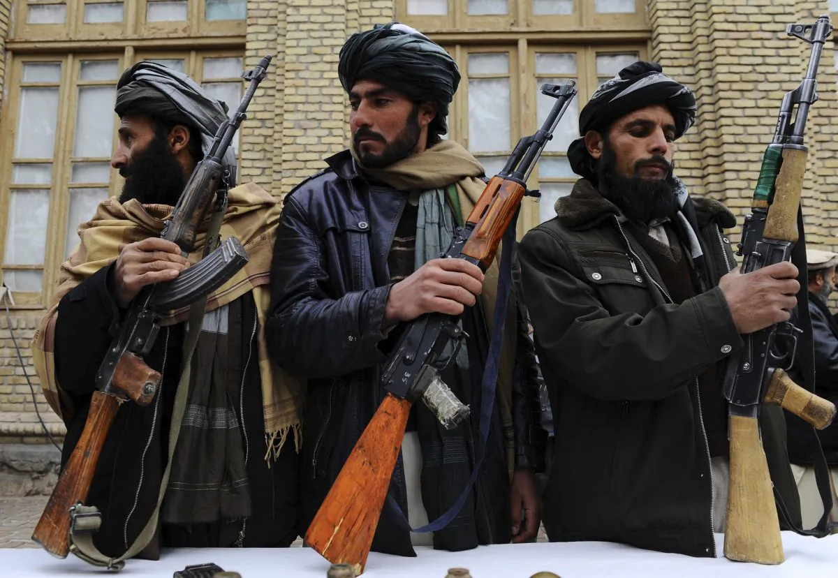 Three former Taliban fighters handover their weapons as they join a government peace and reconciliation process at a ceremony in Herat, Afghanistan, on Jan. 11, 2014. (Aref Karimi/AFP/Getty Images)