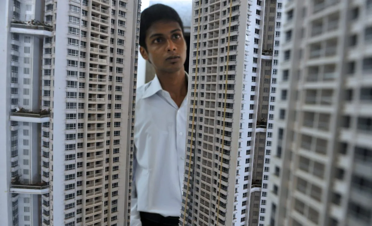 Indian sales executive looks at a model of an luxury apartment complex on a construction site of an apartment tower in Mumbai on August 9, 2010. (Punit Paranjpe/AFP/Getty Images)