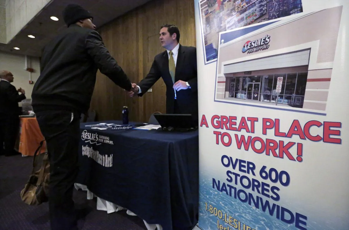 In this April 22, 2015 photo, a sign at a recruiting station for Leslie's Pool supplies boasts that it is a great place to work during a National Career Fairs job fair, in Chicago. (AP Photo/M. Spencer Green)