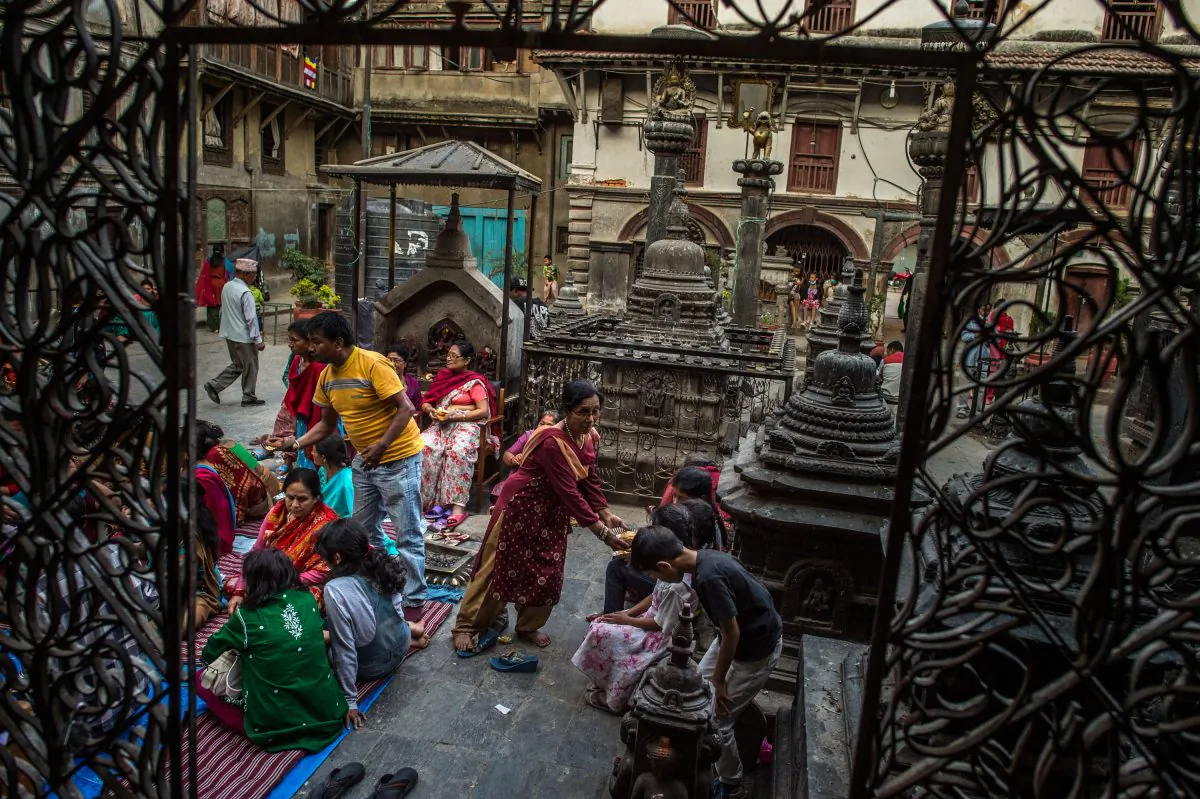 A woman shares food during a celebration in a temple in Kathmandu, Nepal, on May 4, 2015. The magnitude-7.8 earthquake that hit Kathmandu on April 25 has left Nepal scrambling to recover, with women often
taking the lead in relief efforts. (David Ramos/Getty Images) 