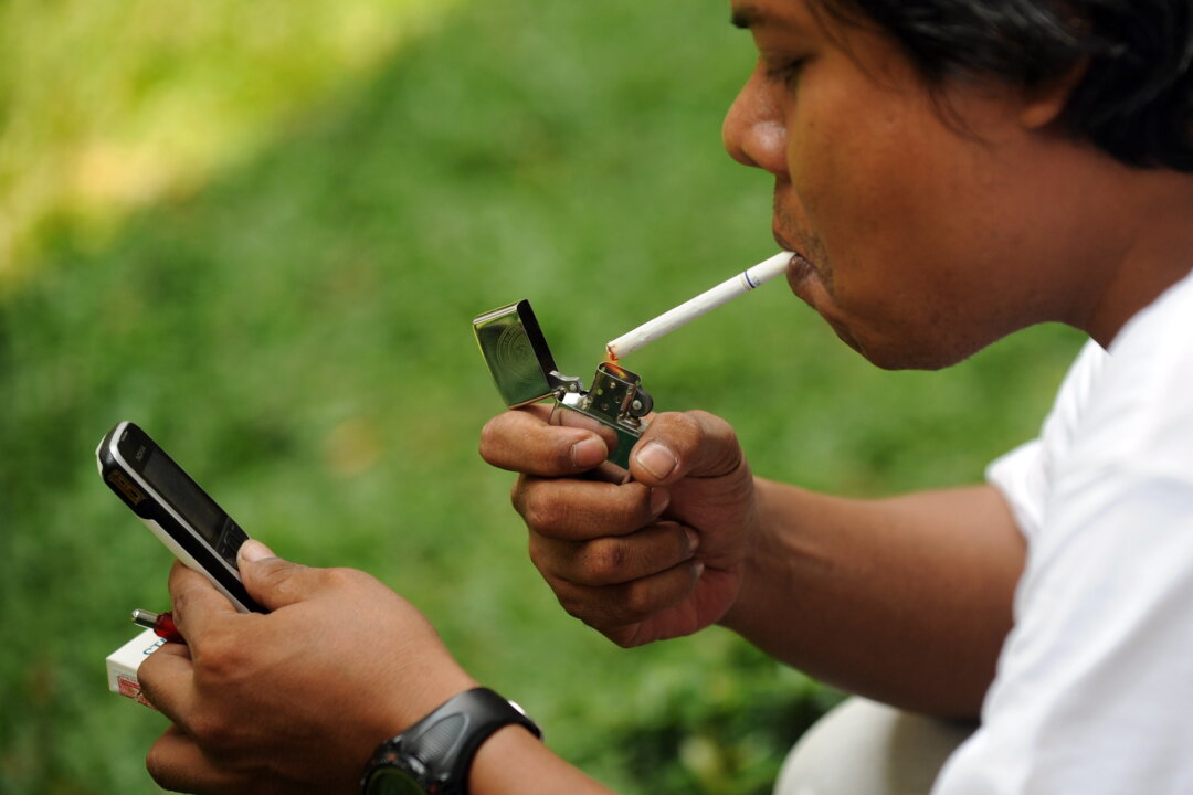 A man lights up a cigarette in Jakarta on Sept. 29, 2010 (Adek Berry/AFP/Getty Images)