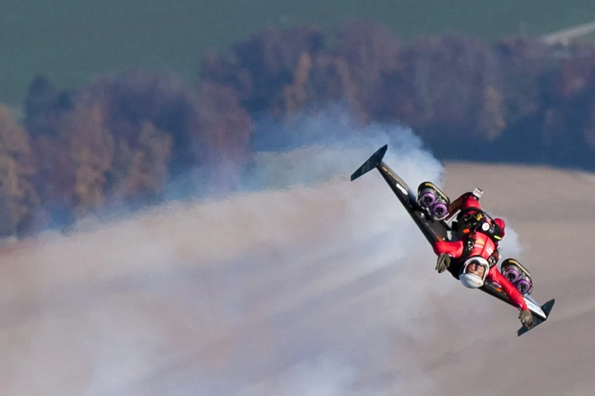 Swiss pilot Yves Rossy, the first man in the world to fly under a jet-fitted wing, speeds through the air performing a looping after launching from a hot air balloon on November 5, 2010 above Bercher, western Switzerland. (LAURENT GILLIERON/AFP/Getty Images)