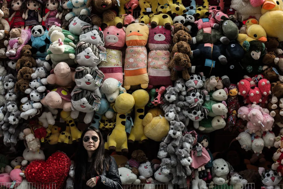 A woman stands in front of a toy display in Hong Kong, Feb. 13, 2015. Chinese companies have been churning out too much merchandise, leading to falling prices—and a worried central bank. (PHILIPPE LOPEZ/AFP/Getty Images)