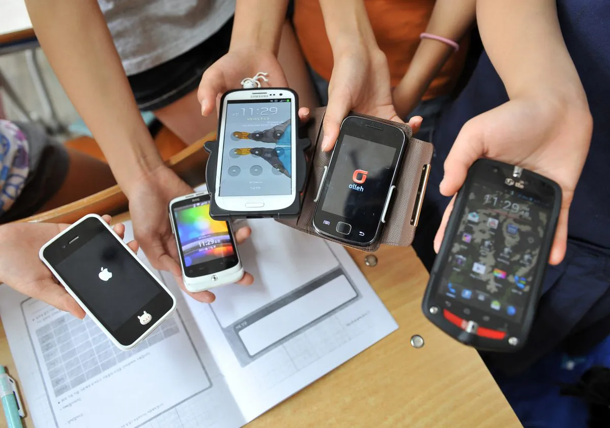 South Korean children displaying their smartphones after a special class on smartphone addiction at an elementary school in Seongnam, south of Seoul, on June 11, 2013. (Jung Yeon-Je/AFP/Getty Images)