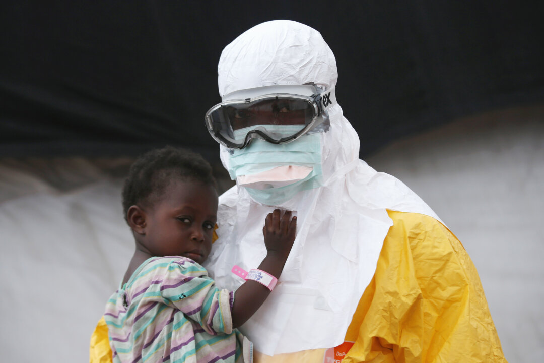  A Doctors Without Borders (MSF), health worker in protective clothing holds a child suspected of having Ebola in the MSF treatment center on October 5, 2014 in Paynesville, Liberia. (John Moore/Getty Images)
