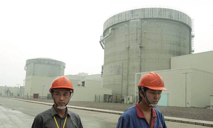 Workers walk past a nuclear power plant in Qinshan, 90 miles southwest of Shanghai, China, on June 10, 2005. (AP Photo/Eugene Hoshiko)