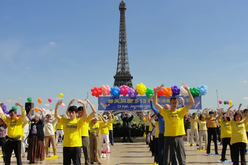 Practitioners from all ages demonstrate the exercises of Falun Dafa in front of the Eiffel Tower in Paris during World Falun Dafa Day on May 13, 2015. (Epoch Times)