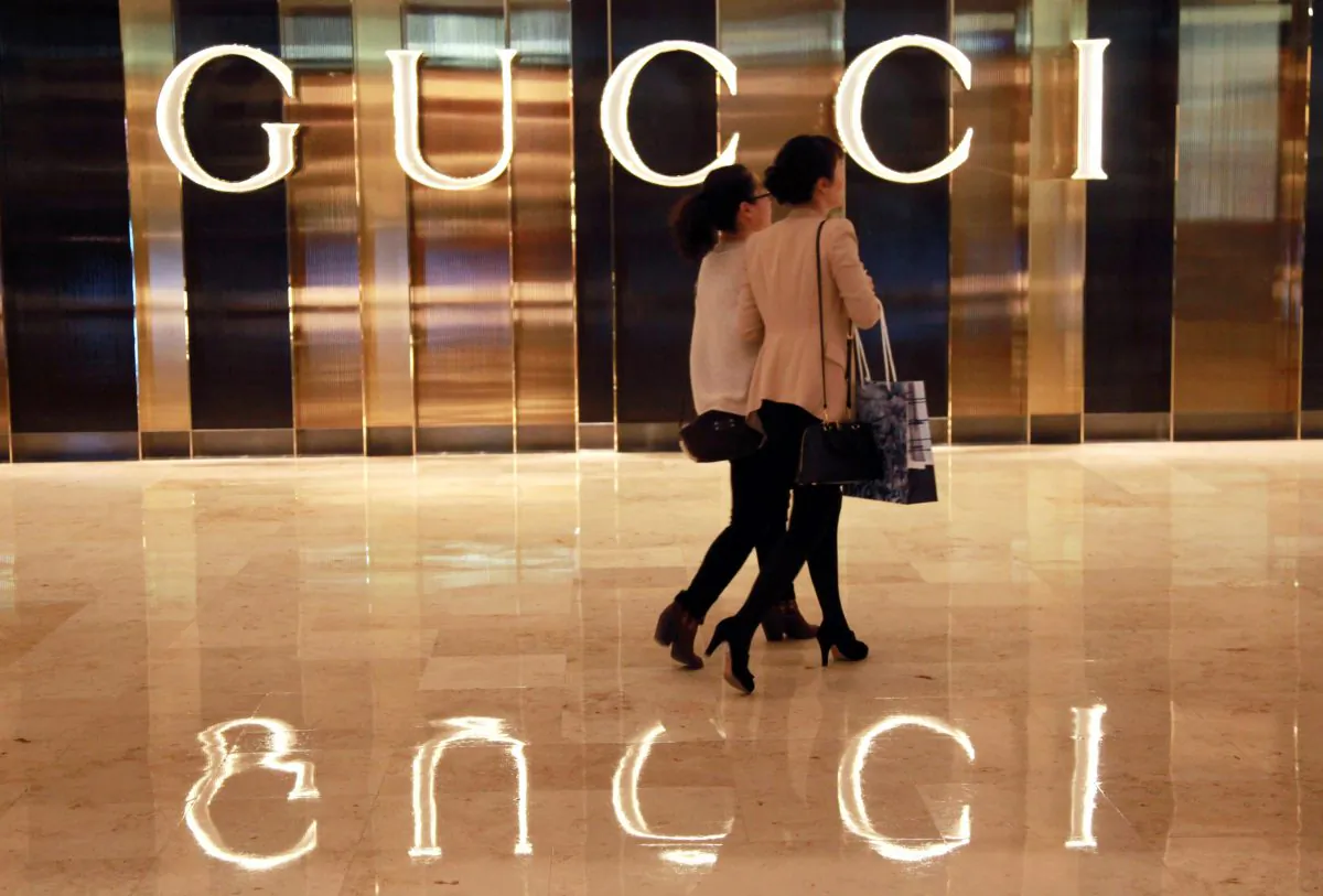 Chinese shoppers walking past a Gucci shop in Nanjing, east China's Jiangsu province.  (STR/AFP/Getty Images)