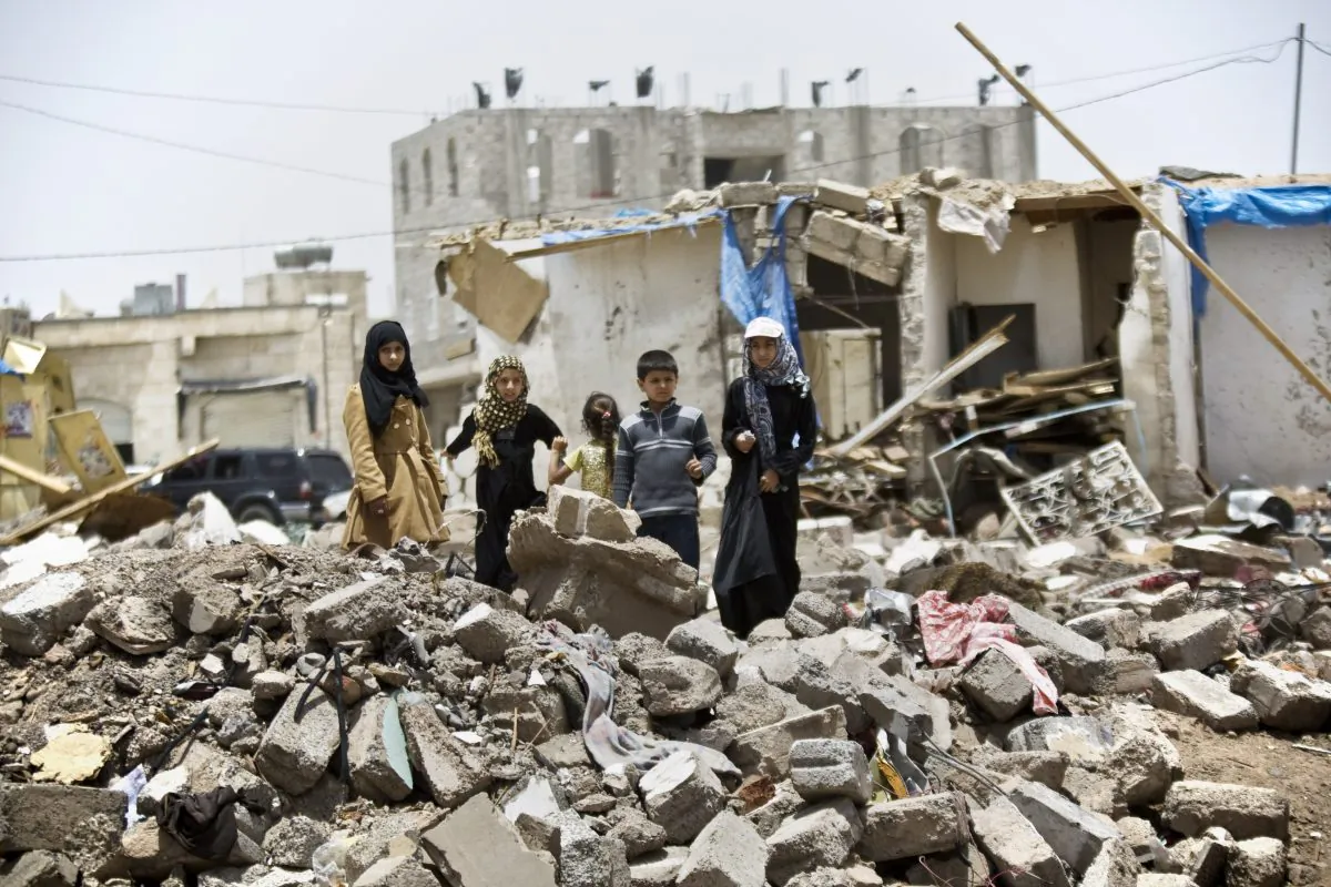 A boy and his sisters watch graffiti artists spray on a wall, commemorating the victims who were killed in Saudi-led coalition airstrikes in Sanaa, Yemen, Monday, May 18, 2015. (AP Photo/Hani Mohammed)