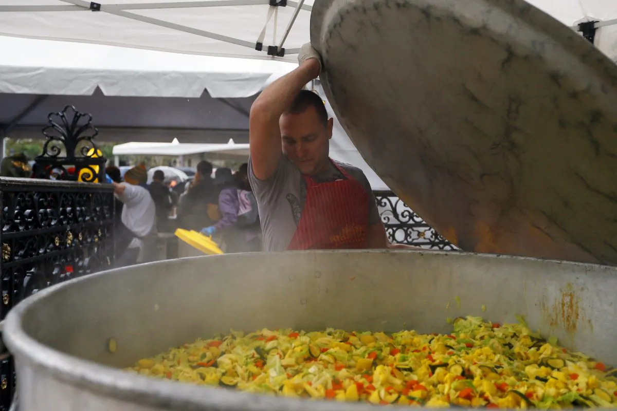 A man cooks vegetables during an event to raise awareness of the food waste on October 13, 2012 at the Place de l'Hotel de Ville in Paris. (Kenzo Tribouillard/AFP/GettyImages)