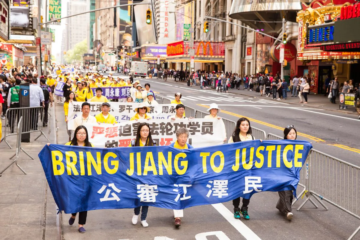 Falun Gong practitioners hold a banner in reference Jiang Ziemin, the previous leader of China who is responsible for conducting the persecution of Falun Gong, during a Falun Gong parade in Manhattan on May 15, 2015. (Edward Dye/Epoch Times)