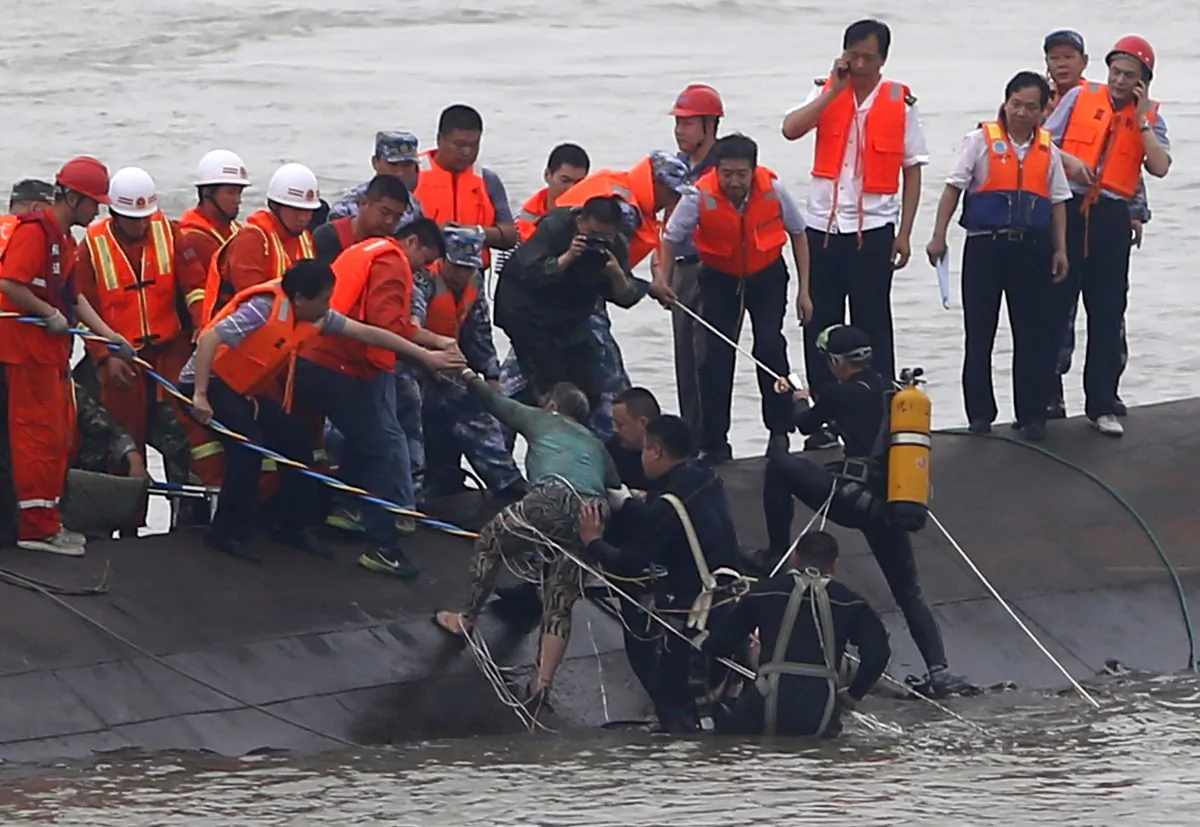 A survivor (C-green top) is rescued by divers from the Dongfangzhixing or "Eastern Star" vessel which sank in the Yangtze river in Jianli, central China's Hubei province on Tuesday. 