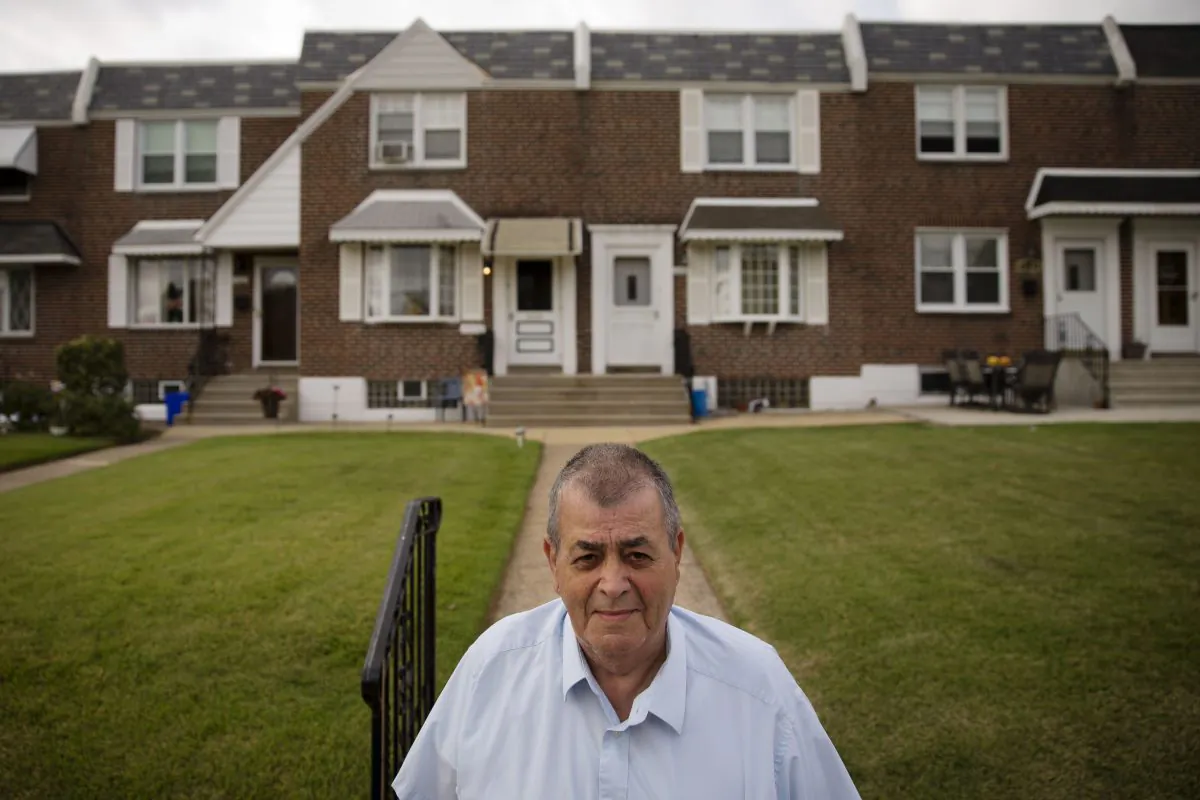 In this Thursday, Sept. 11, 2014 photo, Myles Griffin, 74, poses for a photograph in front of his home in Philadelphia. Griffin has lived with his wife for 40 years in their three-bedroom row home and after retiring three years ago, the couple signed up for a reverse mortgage in May. (AP Photo/Matt Rourke)