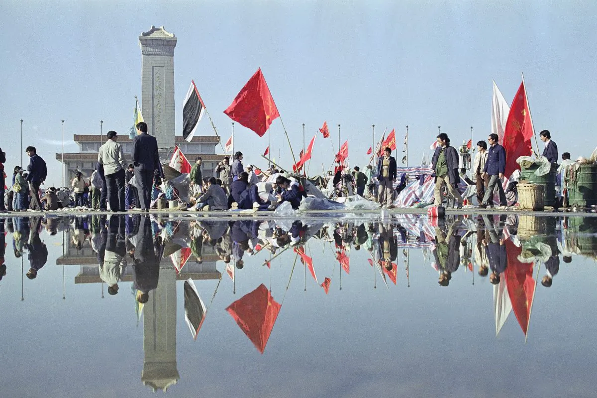 Morning activity in Beijing's Tiananmen Square is reflected in the wet pavement, May 24,1989, following a downpour the night before. In the background are the Martyrs monument and beyond that, Mao's mausoleum. (AP Photo/Mark Avery)
